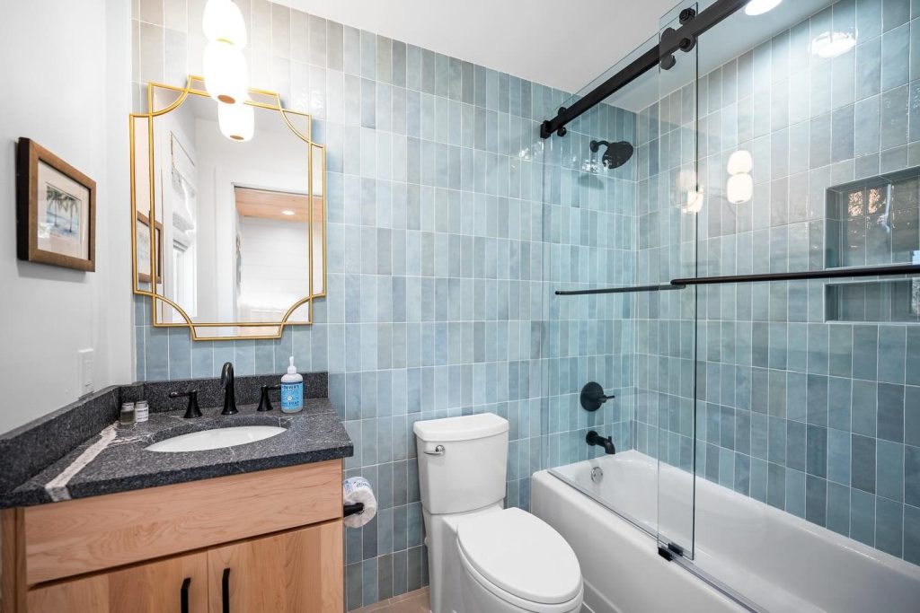 interior shot of bathroom with black granite vanity and sliding glass door shower